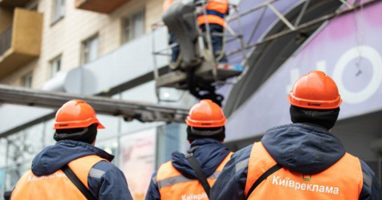 Робітники демонтують рекламні вивіски. Фото: Київреклама